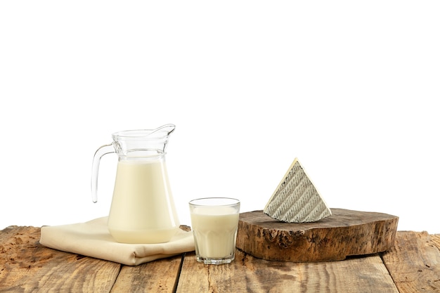 Different milk products, cheese, cream, milk on wooden table and white wall. Healthy eating and lifestyle, organic natural nutrition, diet. Delicious food and drinks.