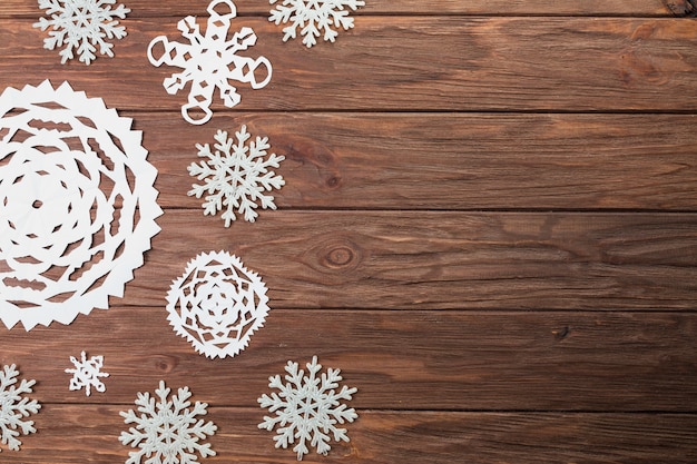 Free Photo different paper snowflakes on wooden board