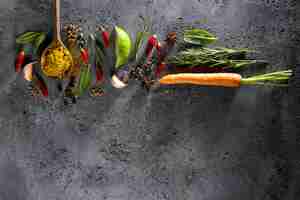 Free photo different spices food ingredients wooden spoon on grey table background