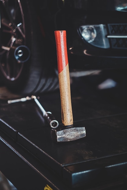 Different tools like wrench and hammer at auto service on the black platform.