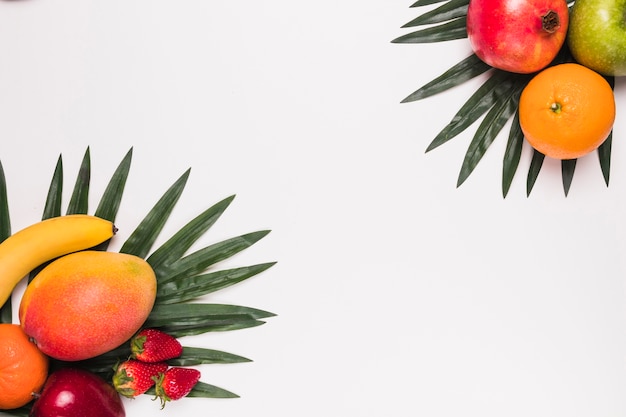 Different tropical fruits on palm leaves