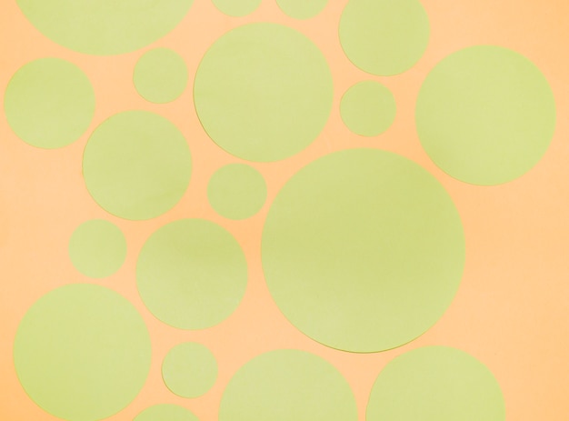 Free photo different type of green paper circles on an orange backdrop