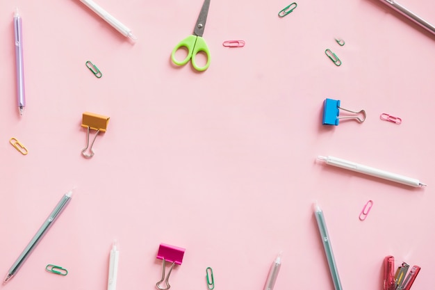 Different type of stationeries on pink background