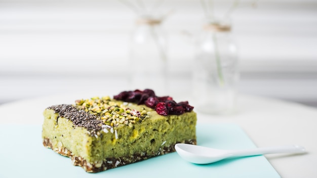 Different types of cake slice with chia; pistachios and dried cranberries toppings on chopping board