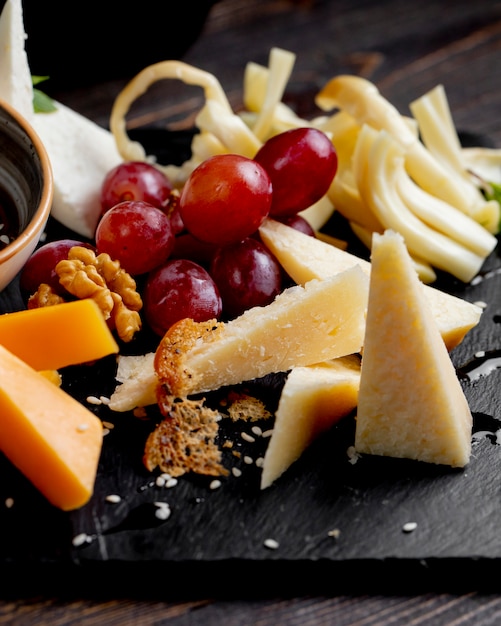 Free Photo different types of cheese with grape and walnuts