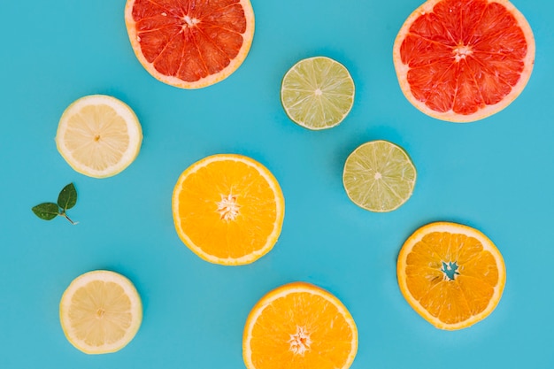 Free Photo different types of citrus fruits slices on blue backdrop