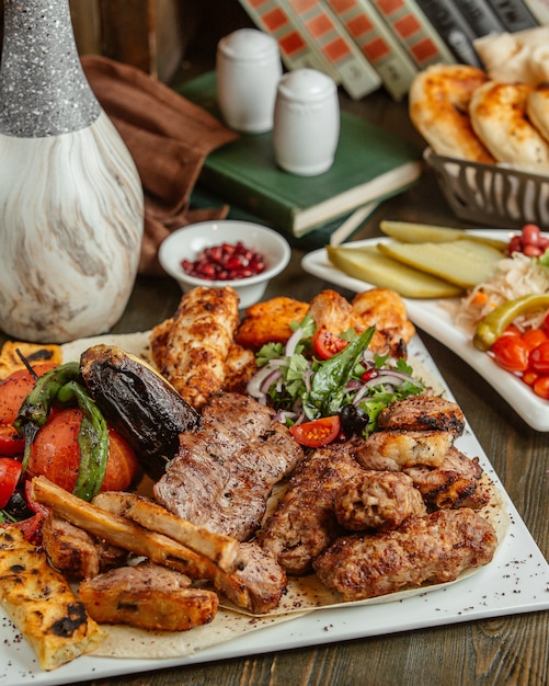 Different varieties of kabab served with grilled eggplants and tomatoes