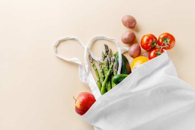 Different vegetables in textile bag on beige