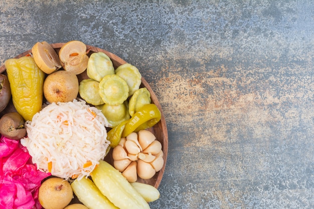 Different vegetables on a wooden plate.