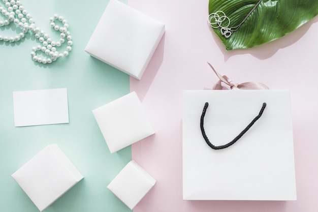 Different white boxes with shopping bag on pink and green background