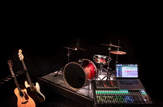 Digital mixer in a recording Studio , with a computer for recording music. On the background of a drum set and musical instruments. The concept of creativity and show business.