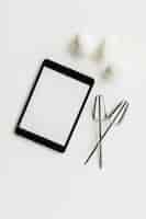 Free photo digital tablet with whisk and eggs on white backdrop