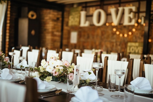 Dining table with floral centerpiece at wedding reception.