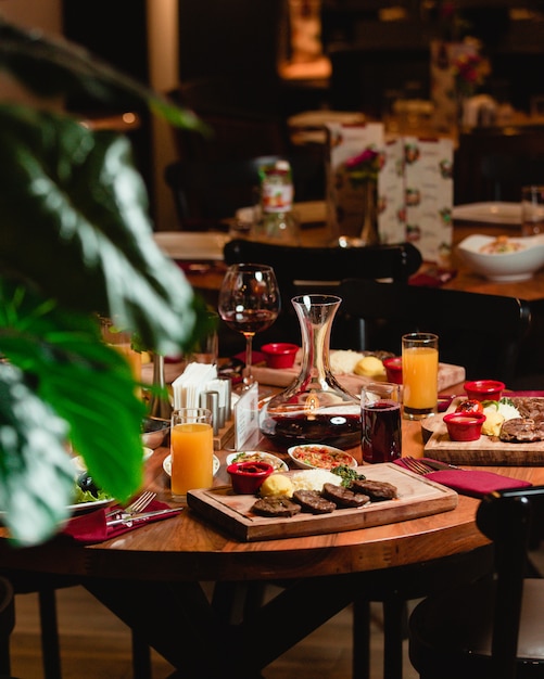 A dinner table with foods and soft drinks in a restaurant.