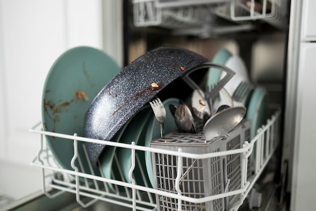 Free photo dirty dishes in washing machine high angle