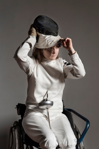 Free photo disabled fencer in special equipment sitting in a wheelchair