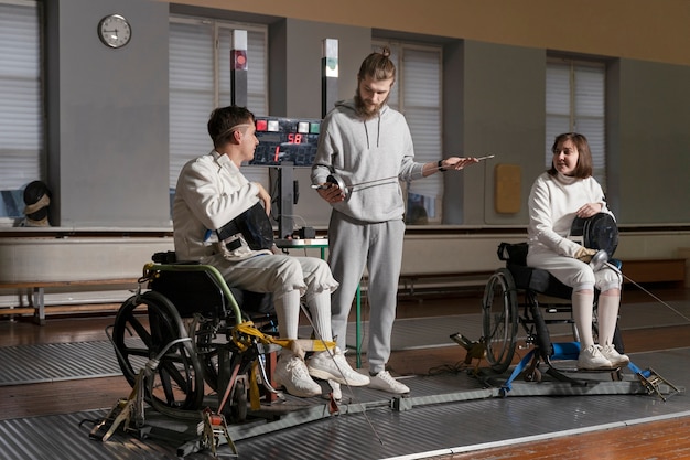 Free photo disabled fencers in special equipment fighting from their wheelchairs