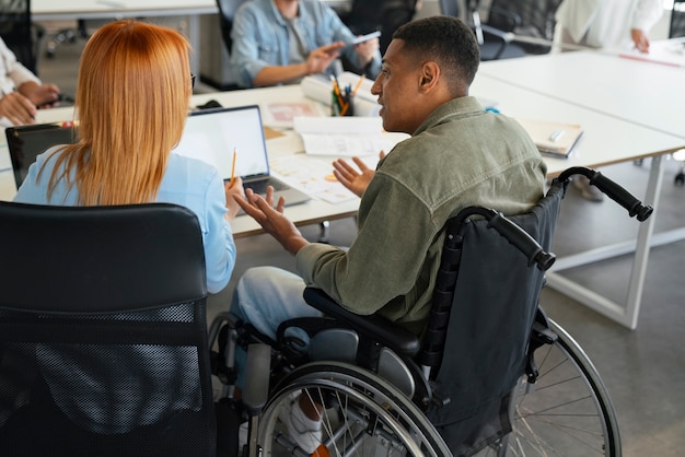 Free Photo disabled man in a wheelchair working at his office job