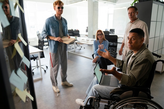 Free photo disabled man in a wheelchair working at his office job