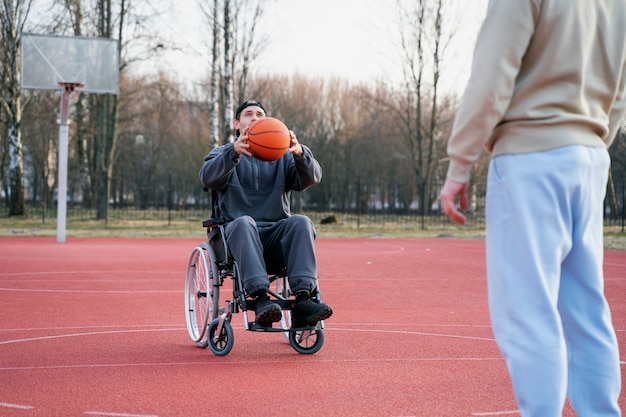 Free photo disabled man with basket ball outdoors