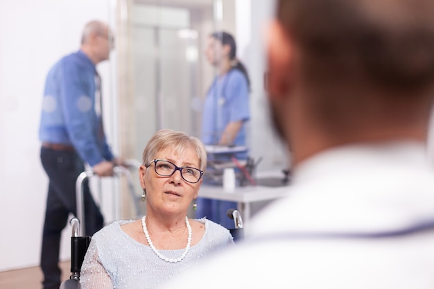 Free Photo disabled old person in wheelchair during treatment with geriatrician doctor