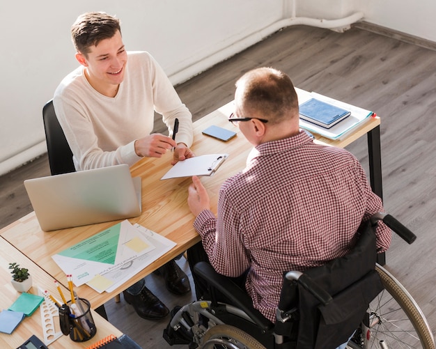 Free Photo disabled worker filling papers for contract