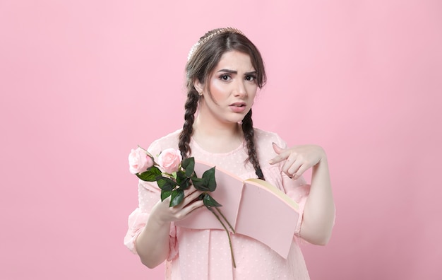 Free photo disgusted woman holding roses and pointing at book