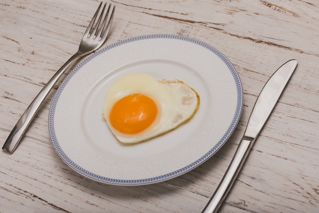 Dish with cutlery and a fried egg