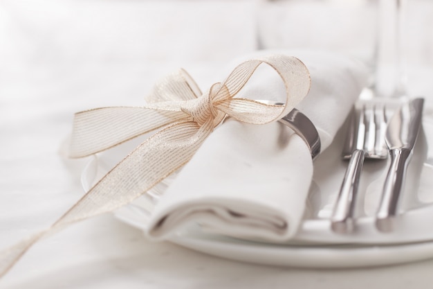 Dish with cutlery and a napkin with a bow