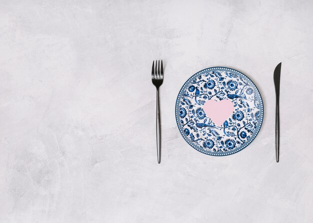 Dish with ornament heart between cutlery