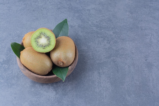 A display of kiwi fruits in bowl on marble table.