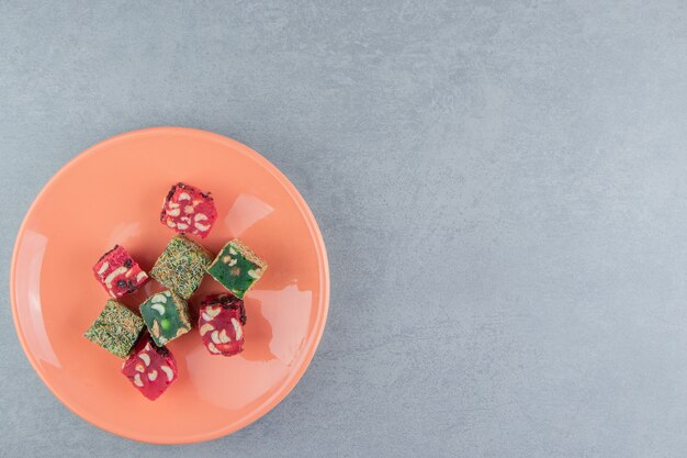 A display of Turkish delight in a plate on the marble background. High quality photo