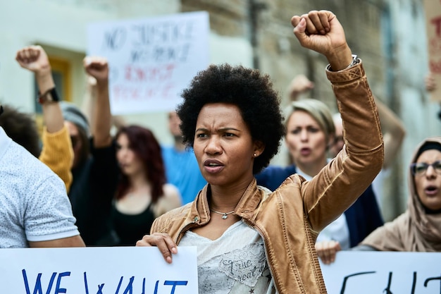 Free photo displeased black woman and crowd of people demonstrating against racism on city streets