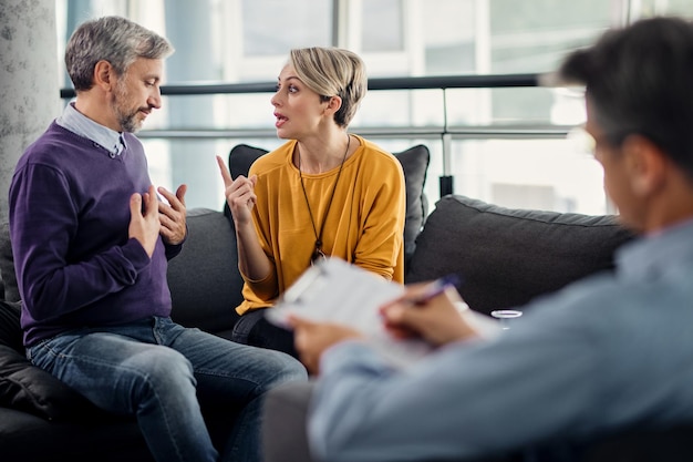 Free photo displeased couple arguing during a meeting with their therapist in the office