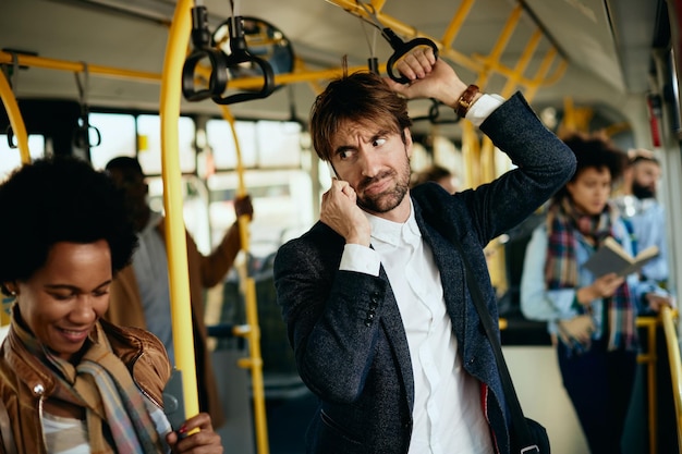 Free Photo displeased entrepreneur making a phone call while commuting to work by bus