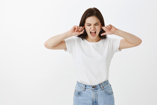 Free photo displeased young woman posing against white wall