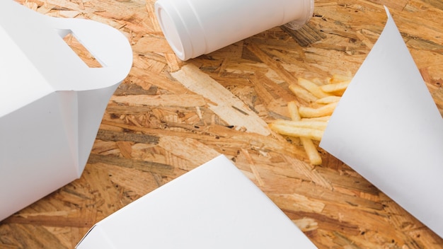 Free photo disposal cup and food parcel mock up on wooden background