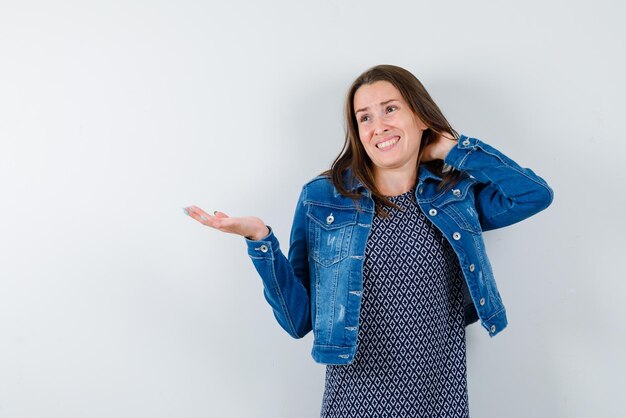 The dissatisfied woman is pointing to left with her hand on white background