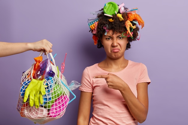 Dissatisfied woman posing with garbage in her hair