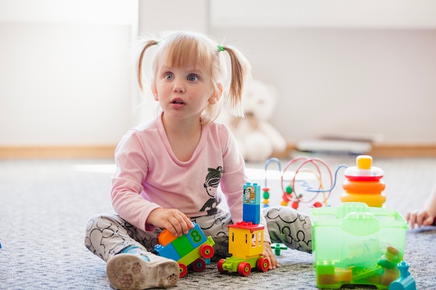 Distracted girl with toys looking away