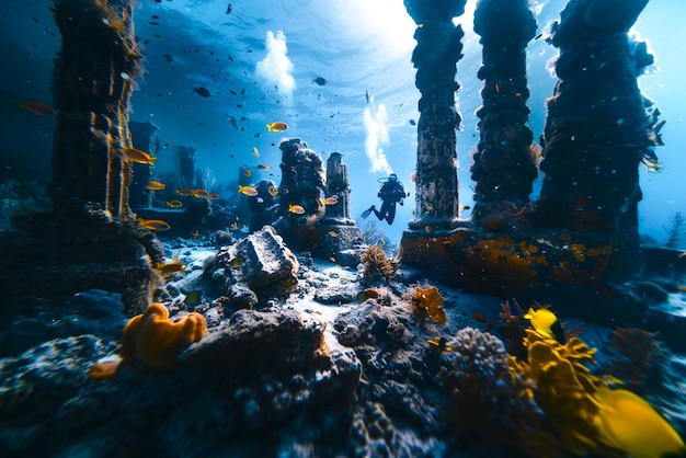 Free Photo diver under the sea surrounded by archeological building ruins