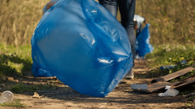 Diverse activists cleaning up rubbish in a garbage disposal bag