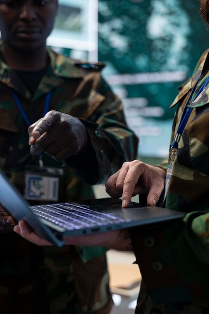 Free photo diverse army staff collecting real time data on a laptop in control room