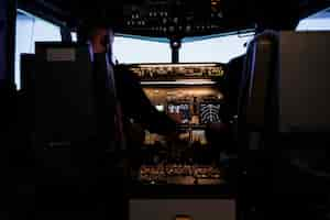 Free photo diverse team of captain and pilot pushing engine throttle lever to takeoff with airplane from aviation cockpit. aircrew men flying plane jet using dashboard and control panel command.