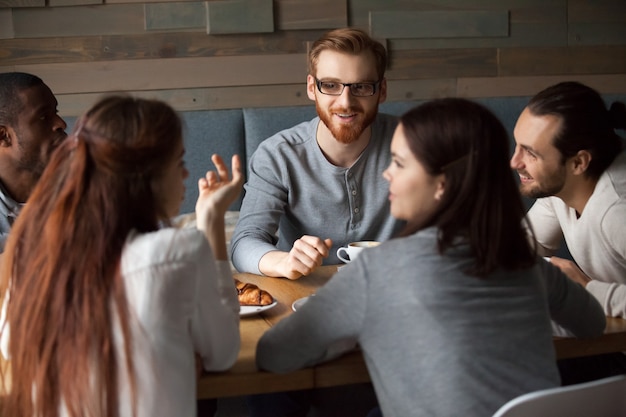 Free photo diverse young people talking and having fun together in cafe