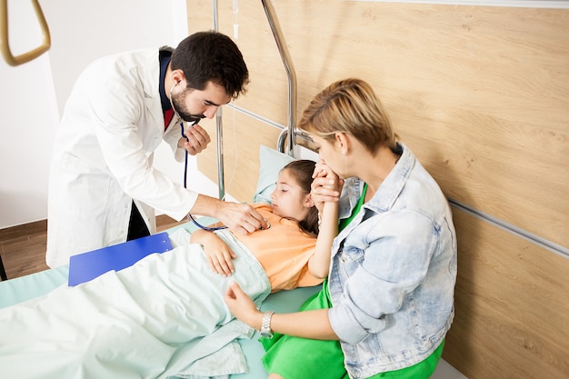 Doctor checking her patient heart  in hospital