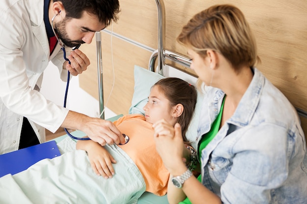 Doctor checking her patient heart  in hospital