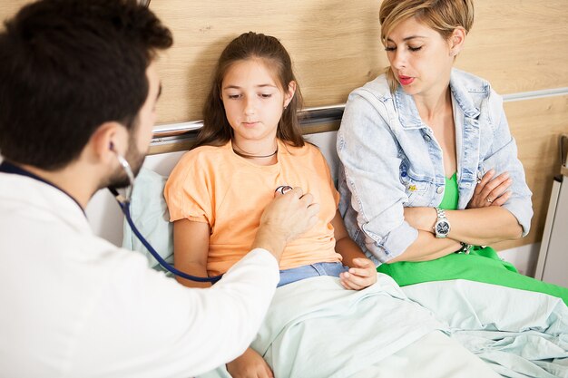 Doctor checking her patient heart  in hospital