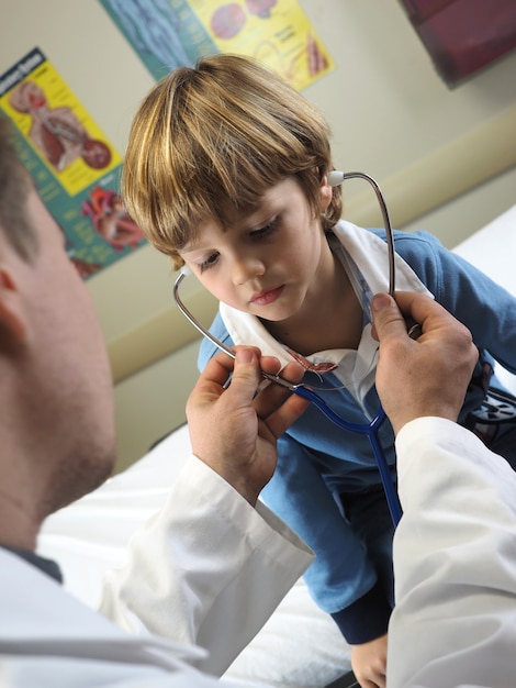 Free photo doctor checking a little boy in a hospital