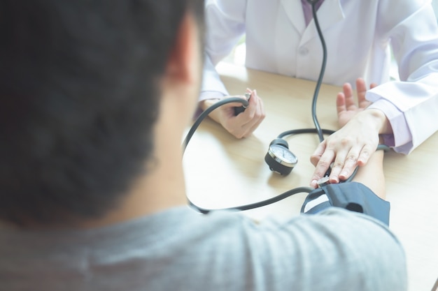 Doctor checking  patient arterial blood pressure